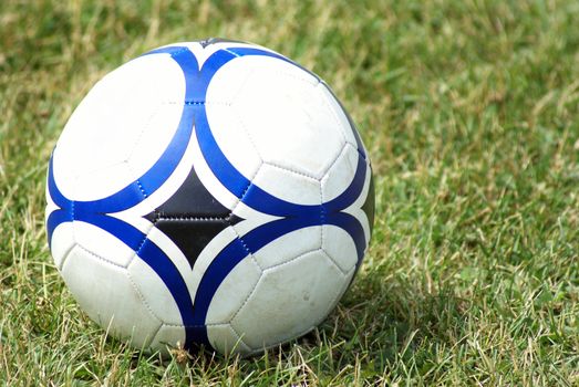 A soccer ball sits on the field of grass.