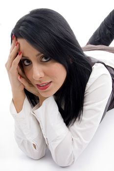 caucasian model lying down on floor and looking at camera against white background