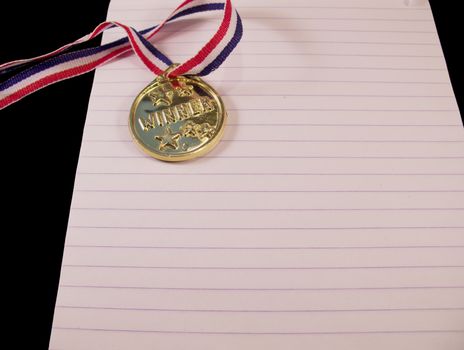 Golden medal with ribbon on note block