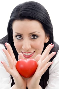caucasian model holding small red heart against white background
