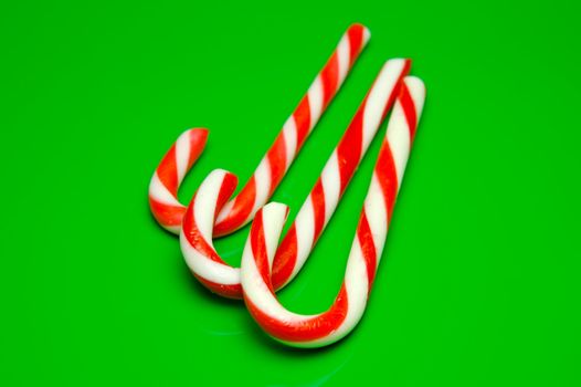 Christmas candy canes isolated against a green background