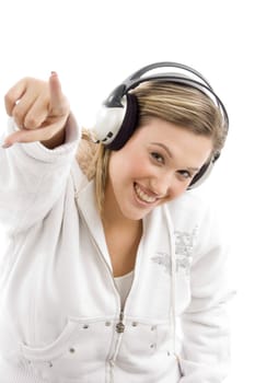 young female pointing in front of camera and wearing headphones with white background