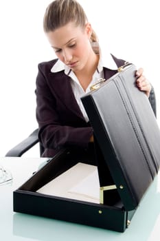blonde woman looking into suitcase against white background