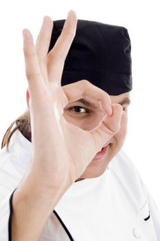 chef looking through finger hole against white background
