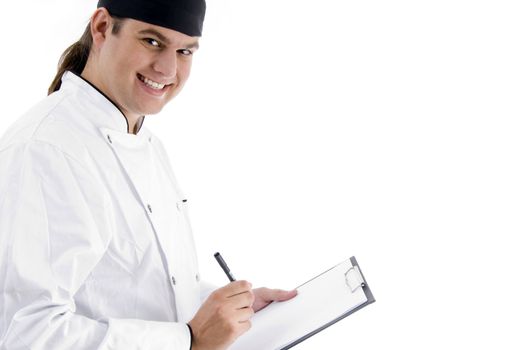 smiling young male chef with clipboard on an isolated white background