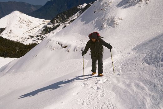 Asian man hiking on ice snow white path in outdoor.