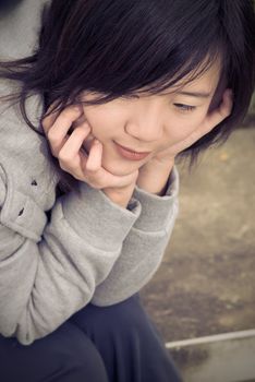 Blue Asian woman sit in outdoor waiting alone.