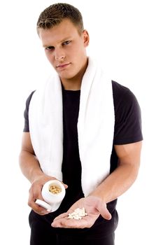 muscular man showing medicine in his palm on an isolated background