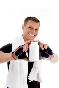 smiling muscular guy showing medicine bottle on an isolated background