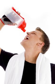 portrait of muscular man drinking from water bottle on an isolated white background