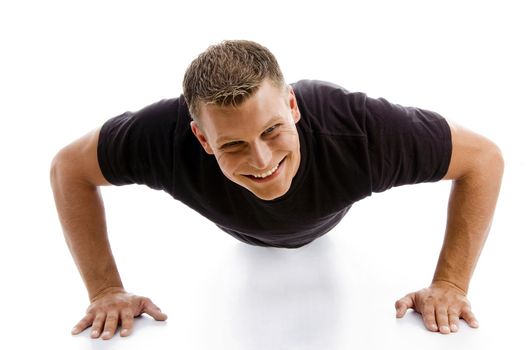 smiling muscular male doing push ups against white background