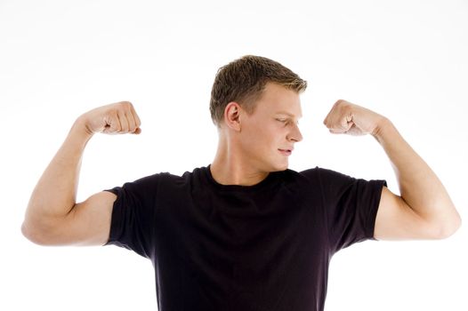 muscular man looking his muscles with white background