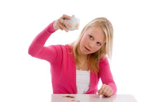 Cute teenager holding her piggybank upside to check if it is empty