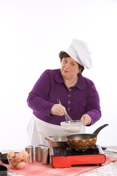 Female chef working above the stove mixing her ingredients