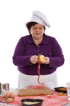 Female chef working in the kitchen and peeling an apple