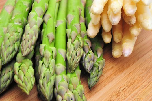 Green and white Asparagus on a Bamboo cutting board