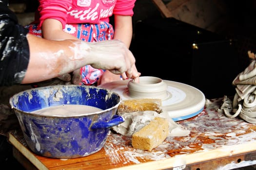 potter learn child shaping clay in workshop