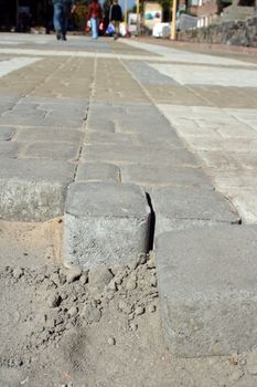 The end of brick pavement with men walking in the distance