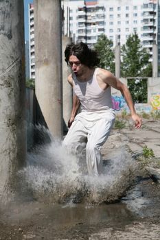 man in white cloth jumps in water, raising dripped