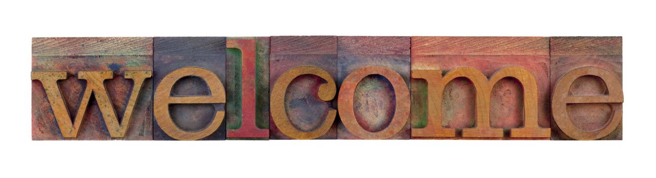 the word welcome in vintage wood letterpress type blocks, stained by color ink, isolated on white