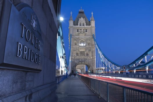 Detail of Tower Bridge in London at dusk with car light trail.