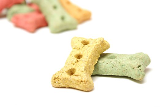 Different coloured dog treats in the shape of a bone.