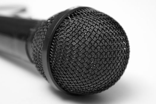 A macro shot of a microphone over a white background.