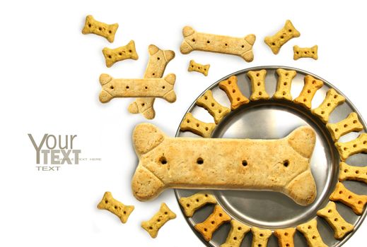 Pile of doggy biscuits  with pewter dish on white