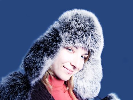 lovely woman in fur hat over blue background