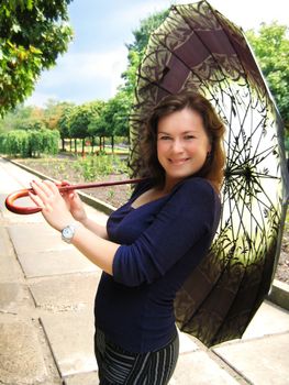 cheerful girl under green umbrella in park