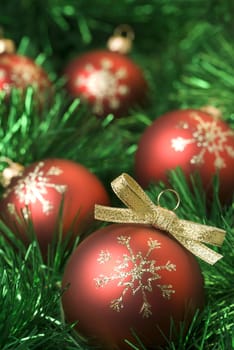 Red christmas balls on the green tinsel. Shallow dof, aRGB.