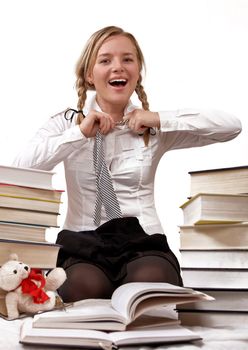 Schoolgirl or student taking off tie. She is fed up with a learning. Is time for the game. Isolated on white. 