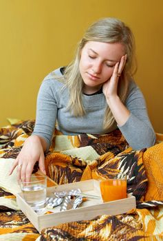 ill woman is sitting on bed