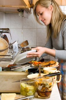 woman washing plates in kitchen