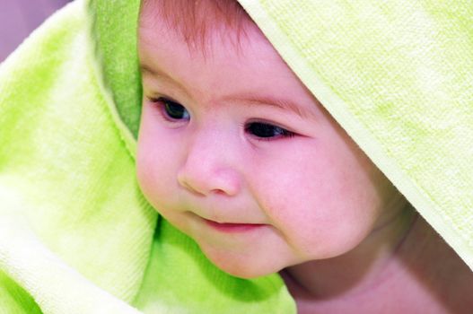 baby looking out from under blanket