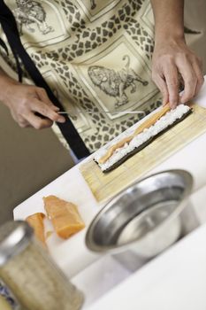 a sushi chef in action preparing a sushi dish with salmon