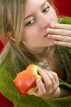 pretty girl is holding a juicy apple in  palm