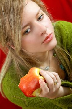 pretty girl is holding a juicy apple in palm