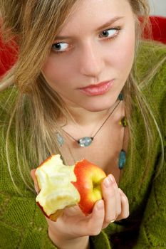 pretty girl is holding a juicy apple in palm