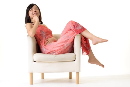 Asian lady sit on sofa at leisure with smiling expression on white background.