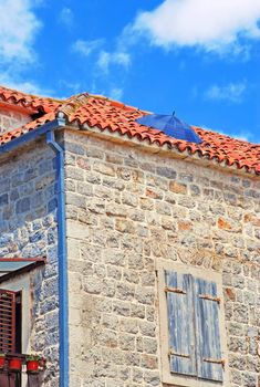 Old stone house exterior in Montenegro - Budva, umbrella on roof