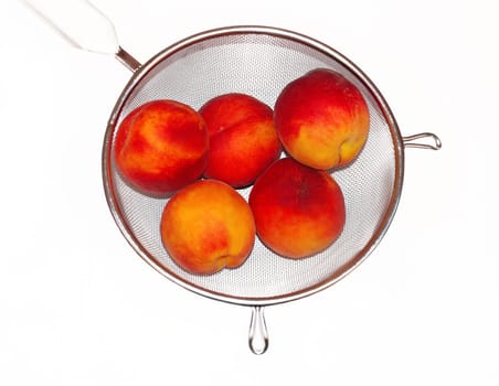 fresh rape peach in colander isolated over white