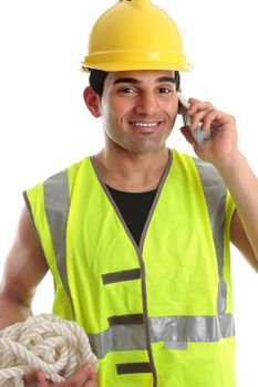 Happy smiling builder, civil engineer, construction worker, labourer using a telephone.  He is wearing yellow hard hat and reflective high visibility vest.  White background.