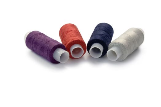 4 spools of the varicoloured threads on white background