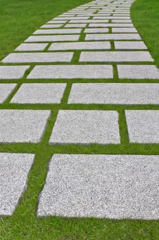 Granite path laid out on a green grass