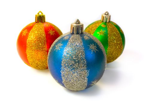 Three multi-coloured fur-tree spheres with spangles on a white background