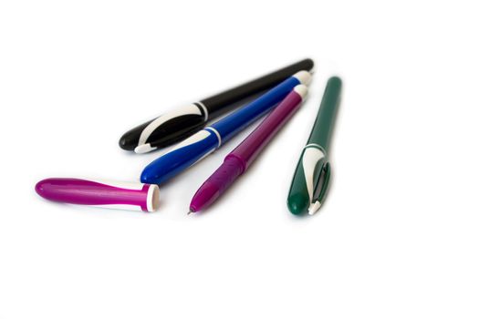 Four pens of different colour on a white background