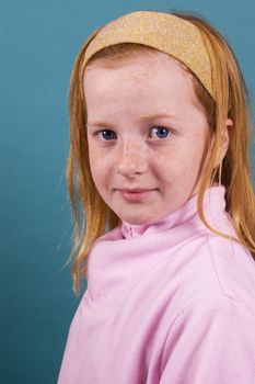 portrait of a red head smiling girl isolated on green