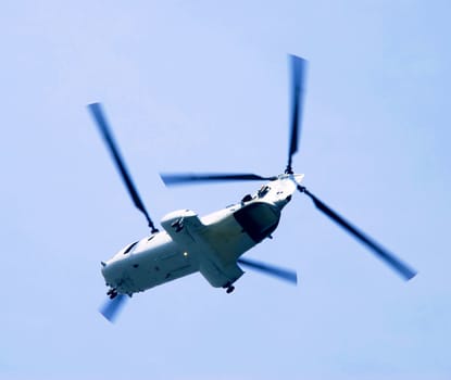 Flying helicopter over blue sky from bottom