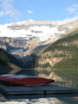 canoes by a lake and mountains